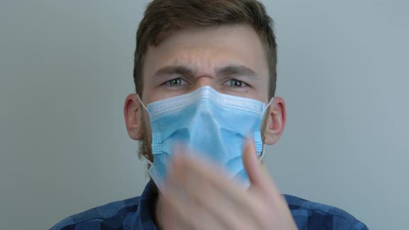 Virus infected man is coughing wearing blue medical mask. Pandemic concept. Coronavirus