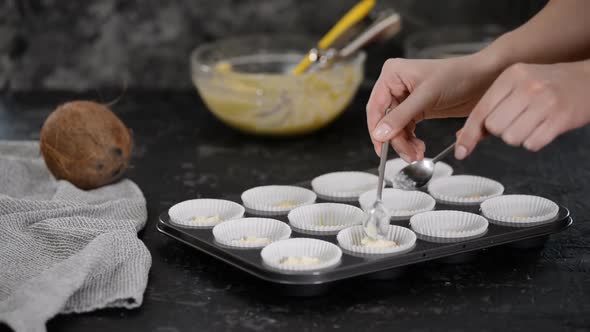 Filling the Paper Molds with Dough To Make Muffins.