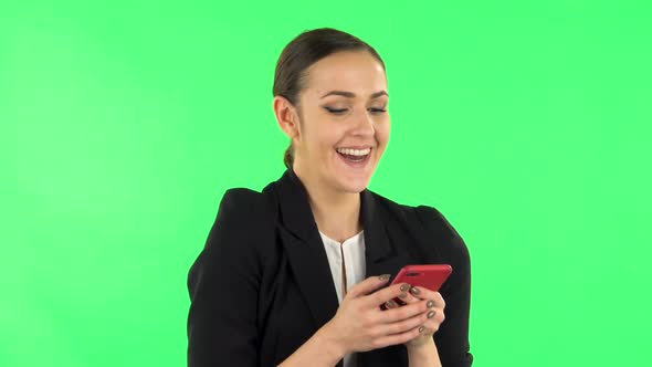 Young Smiling Woman Texting on Her Phone and Rejoice. Green Screen