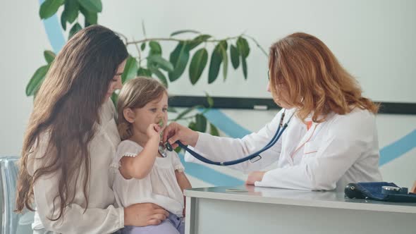 Female Family Doctor Examining and Consulting to Mother and Her Child