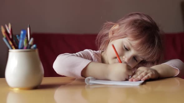 Cute Child Girl Artist Studying Drawing Picture with Pen and Pencils at Home