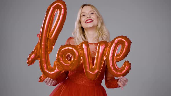 Delighted Woman Playing with Air Balloon in Studio