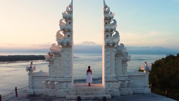 Young Woman in Balinese Gates in Front of Ocean