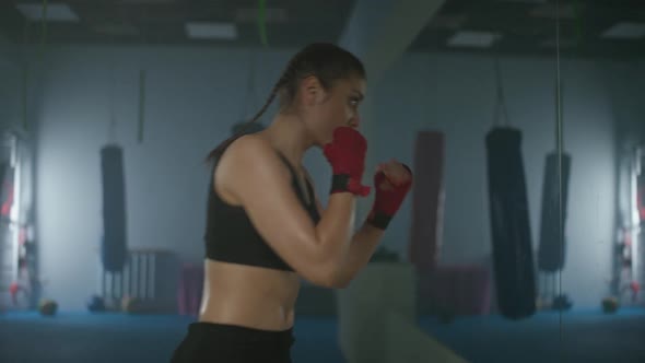 Woman Fighter Trains His Punches and Defense in the Boxing Gym a Boxer Trains in Front of a Mirror