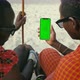 Masai Tribe Men Looking at the Smartphone and Touching Green Screen in the Front of Desert - VideoHive Item for Sale