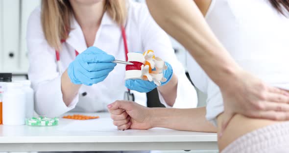 Doctor Showing Hernia on Plastic Spine Model in Front of Sick Patient Closeup  Movie