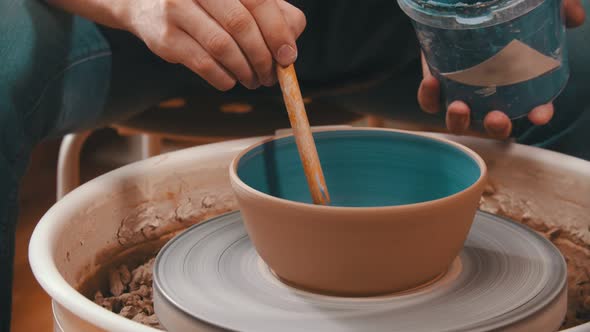 Pottery - the Man Is Painting a Clay Bowl Inside