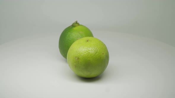 Green Citrus Ripe Lime Rotating Clockwise On The Table With White Background - Close Up Shot