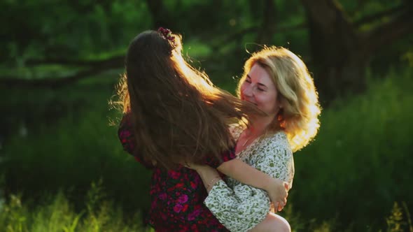 Young Woman and Child Hugging in Field