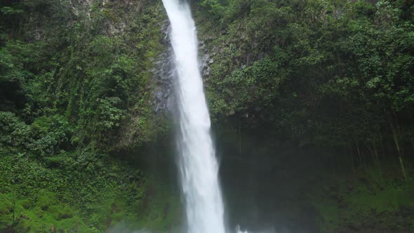 La Fortuna Waterfall flowing in the lush Costa Rica rainforest, Tilt Shot