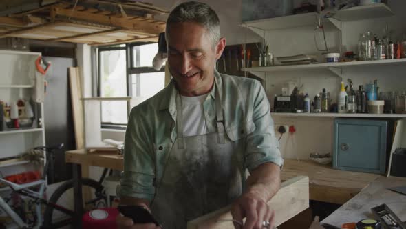 Man doing DIY at home using smartphone