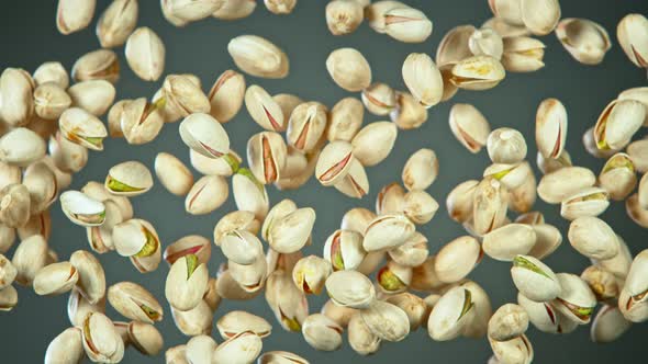 Super Slow Motion Shot of Flying Pistachios After Being Exploded on Grey Background at 1000Fps