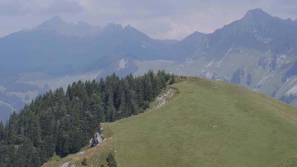 Circling around hill with mountain summits in the background. Fribourg, SwitzerlandInspire2 drone w