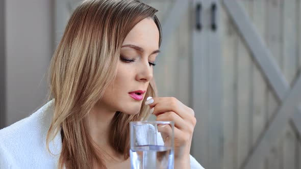 Closeup Sickness Blonde Girl in Wrapped Plaid Drinking Painkiller Pills