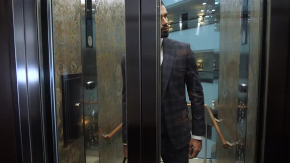 Confident Businessman Exiting Hotel Elevator