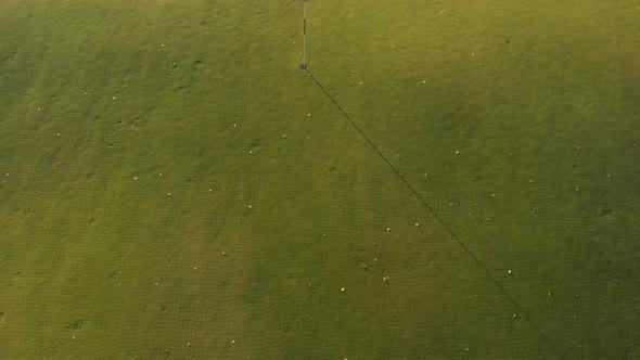 Moving over a white flag on a green golf course.