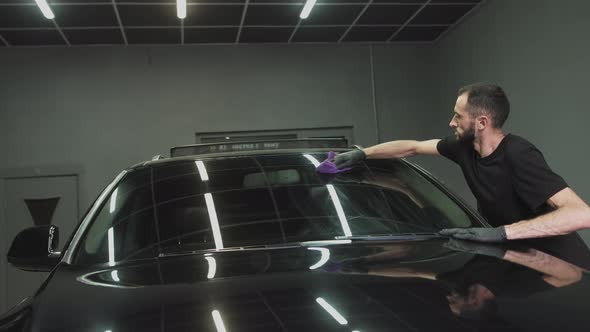 Professional Car Ceramics Worker Applies a Layer of Ceramics Protective Rain