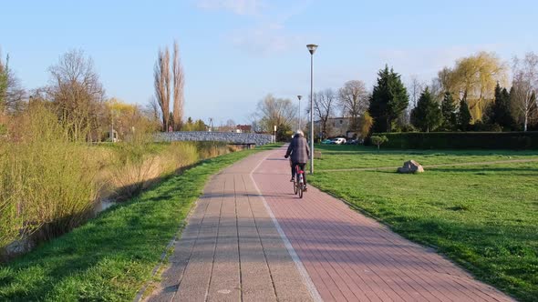 Unrecognizable Old Woman Rides Bicycles in the Park