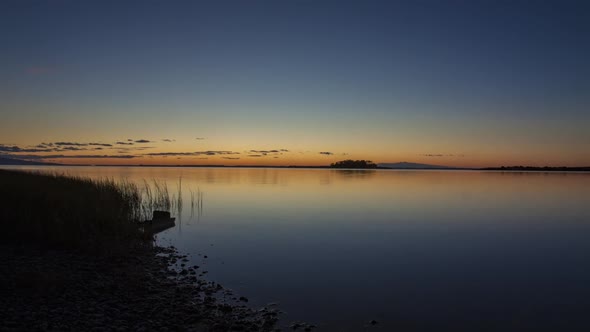 Sunrise on tranquil lake timelapse