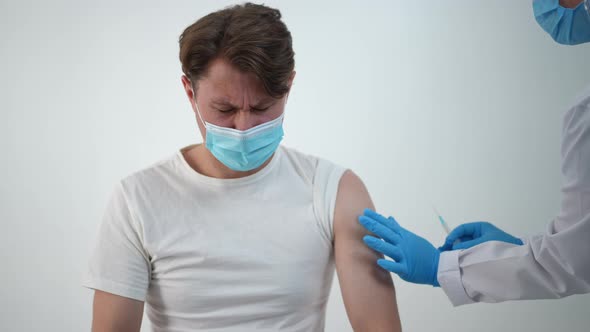 Caucasian Male Patient Feeling Pain in Arm After Coronavirus Vaccination in Medical Clinic