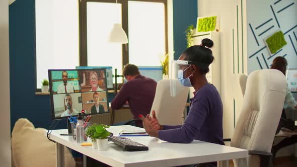 African Worker with Face Mask Talking on Videocall in Office Room