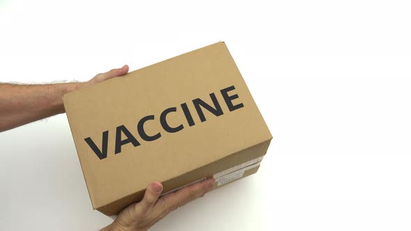 Man Holds the Vaccine Box Against White Background