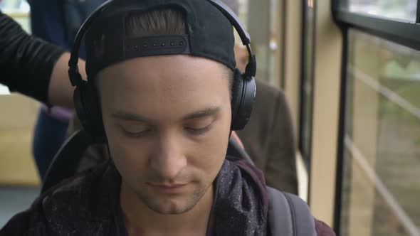 Young Man Listening to Music in Bus