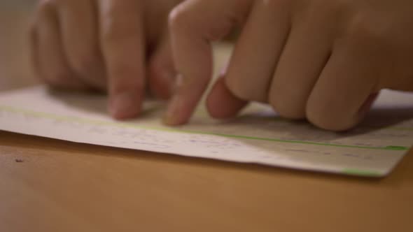 Person learning to read braille lettering.