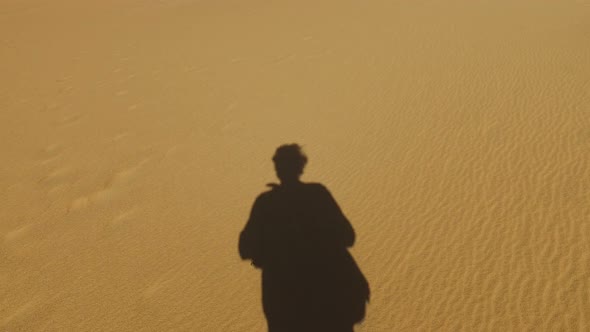 Man's shadow on sand in desert, Egypt