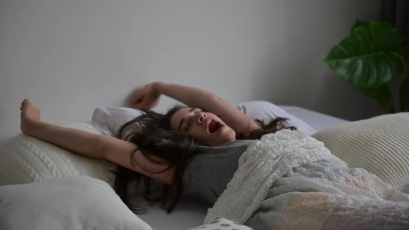 young woman girl on the bed at home, sleepy relaxing in the morning on pillow