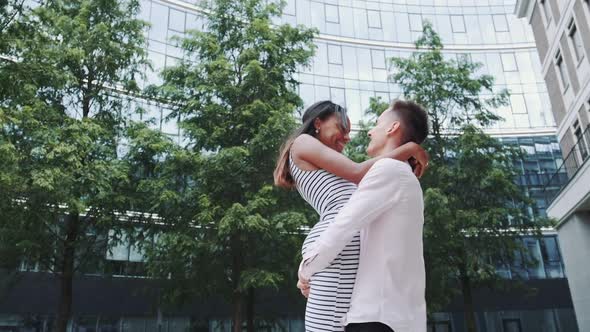 Happy Young Man Spinning Around Beautiful Black Woman in Park