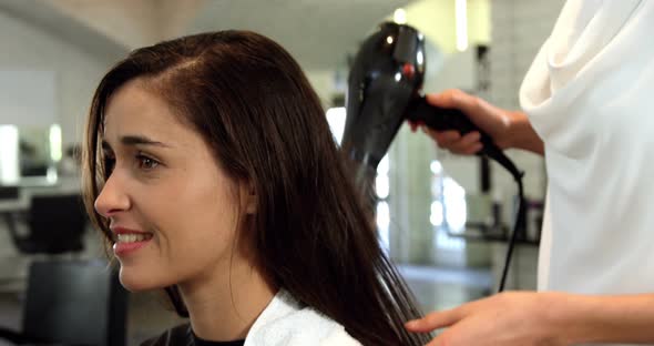 Woman getting her hair dried with hair dryer