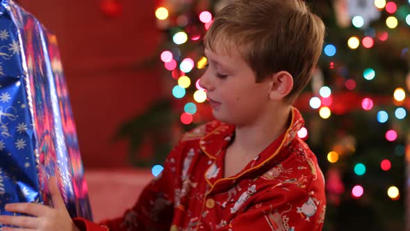 Boy shaking and looking at Christmas gift