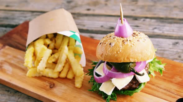 Hamburger and french fries on wooden board