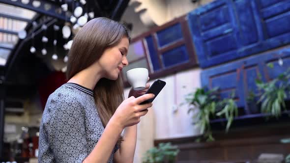 Woman With Phone At Cafe Drinking Coffee