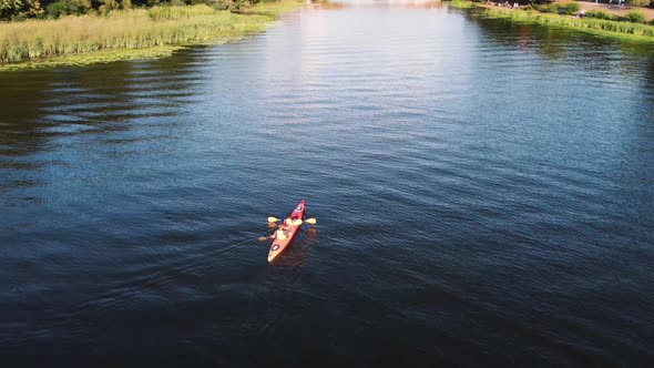 Two guys are canoeing on the river. Drone view