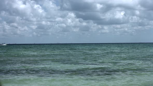 White boat traveling the ocean, in the distance.