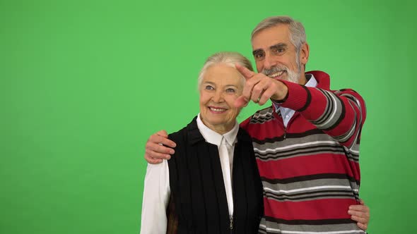 An Elderly Couple Watches Something Off Camera and Talks - Green Screen Studio