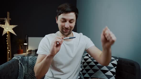 Young Caucasian Man Holding Pregnancy Test in His Hands Very Excited and Happy with Result and