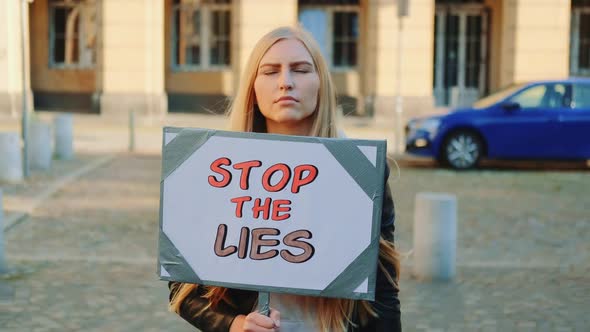 Concerned Woman with Protest Banner Calling to Stop Lies