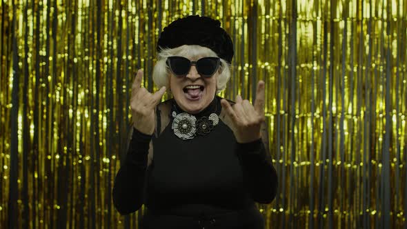 Excited Positive Senior Woman Showing Rock and Roll Gesture and Sincerely Smiling, Showing Tongue