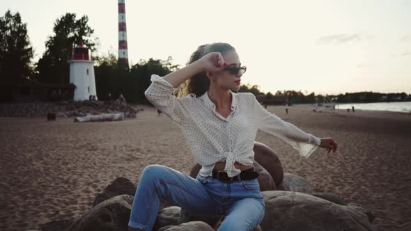 Young Caucasian Girl Relaxing in the Beach on the Shore of Ladoga Lake. Osinovetskiy Lighthouse