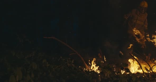 Firemen Jumping Over Fire in Dense Forest Fire Fighter with Safety Equipment and Axe Extinguishing