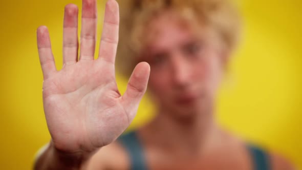 Closeup Male Hand with Blurred Caucasian LGBT Man at Yellow Background