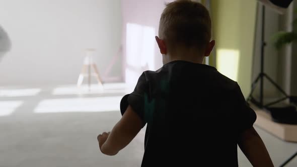 A Little Boy Runs to a Photo Studio