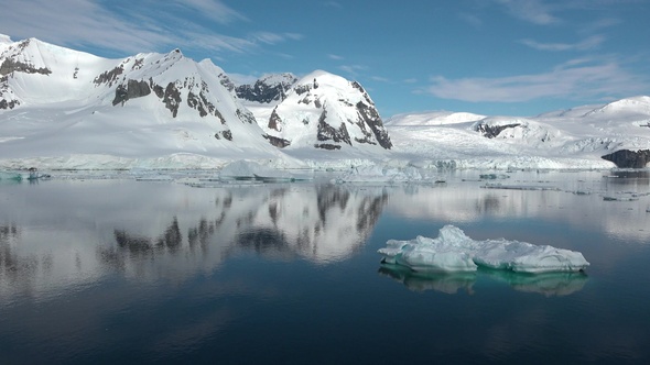 Environment. Reflection of mountains and icebergs in the water. Antarctica. Life of nature.