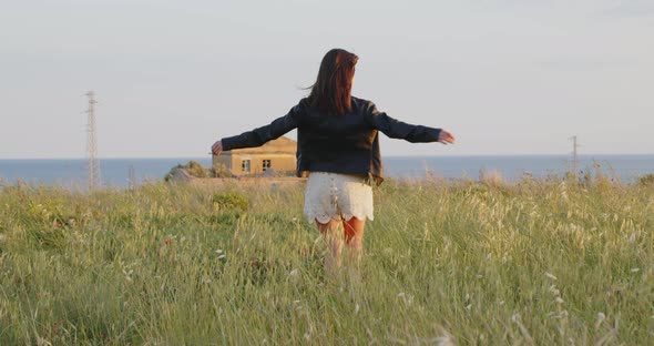 Young girl enjoying. Arms outstretched and happiness.