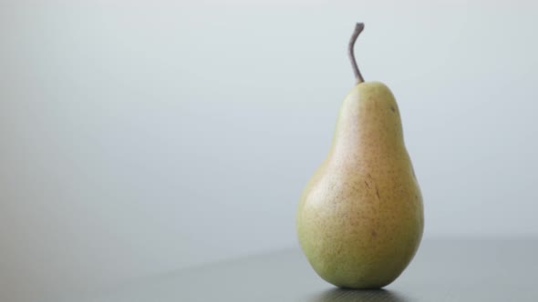 Tilting over  organic pear on wooden  table 4K 2160p UltraHD footage - Single fruit from genus Pyrus