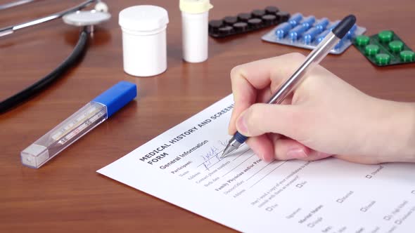 Doctor Writing a Medical History and Screening Form of the Patient