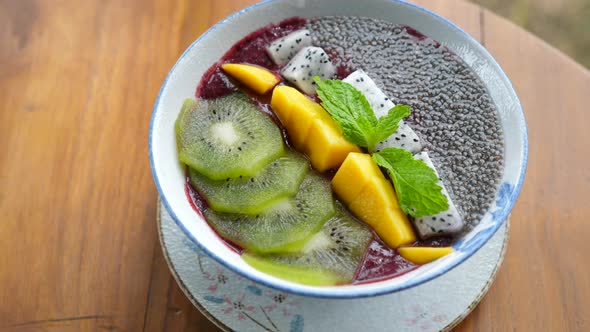 Vegan Food Smoothie Bowl Topped with Kiwi Mango Dragon Fruit and Chia Seeds